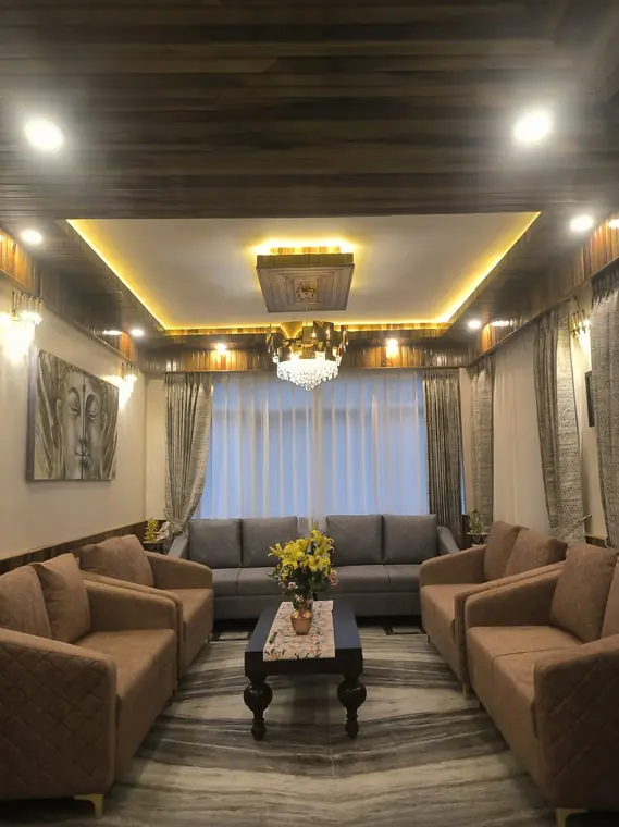 Hotel lounge with sofas, a chandelier and warm cove lighting