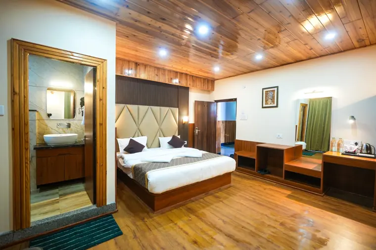 Premium room seen from the doorway, bed made up with a runner
